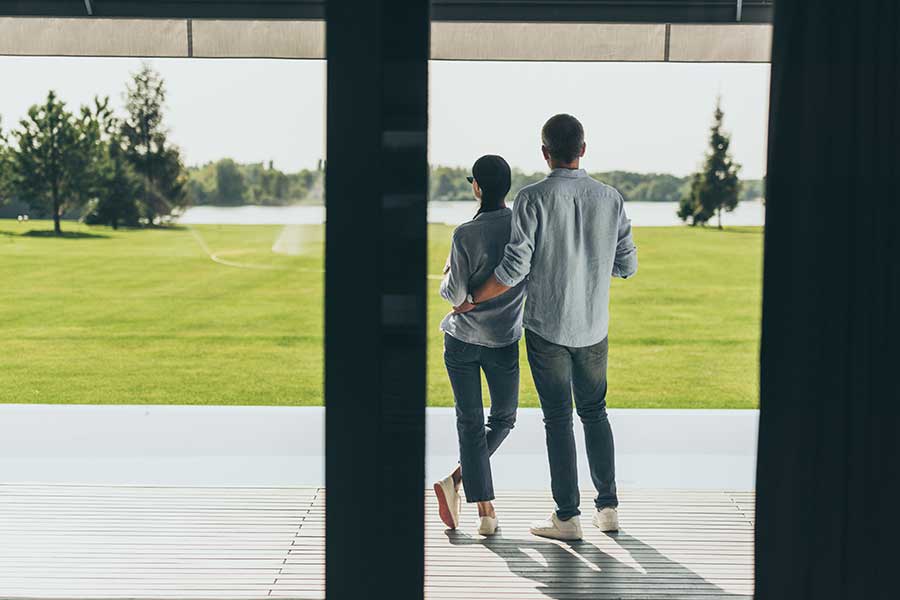 Couple standing on back patio looking into the backyard